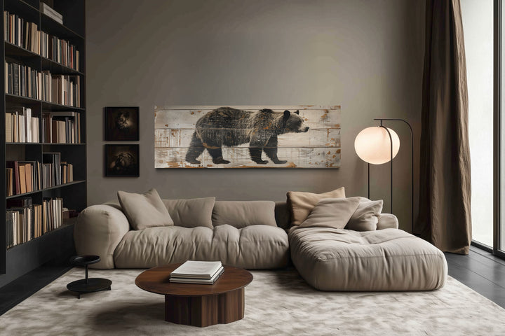 Long horizontal framed canvas wall art of a bear painted on rustic wood grain in a modern cabin.