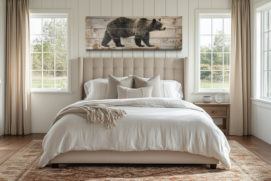 Bear painted on wood long horizontal framed canvas wall art hanging above a bed in a rustic room.