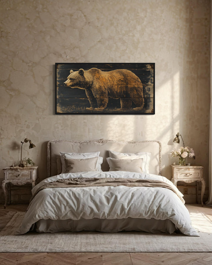 Bear painted on dark wood framed canvas wall art hanging above a bed in a rustic room.
