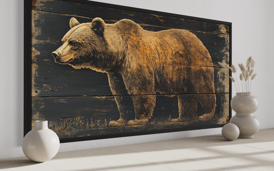 Bear painted on dark wood framed canvas wall art displayed in a rustic cabin setting.