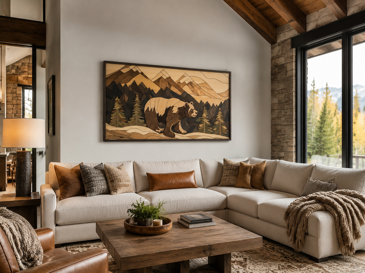 Rustic bear and mountain landscape wood panel wall art above a cream sectional sofa in a cabin.