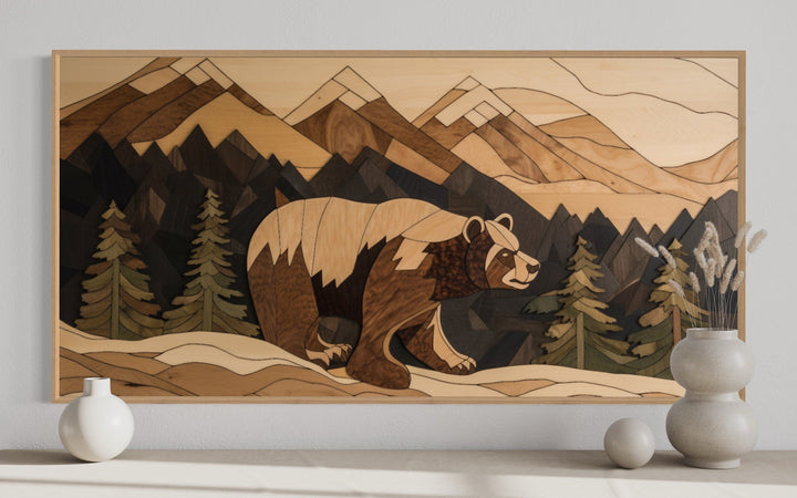 Rustic wood panel wall art of a bear walking through a mountain landscape with pine trees.