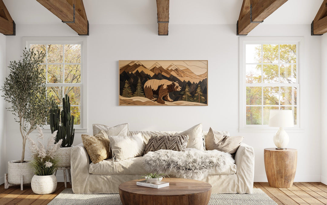 Rustic bear painting on wood panel canvas wall art above a sofa in a mountain cabin living room.