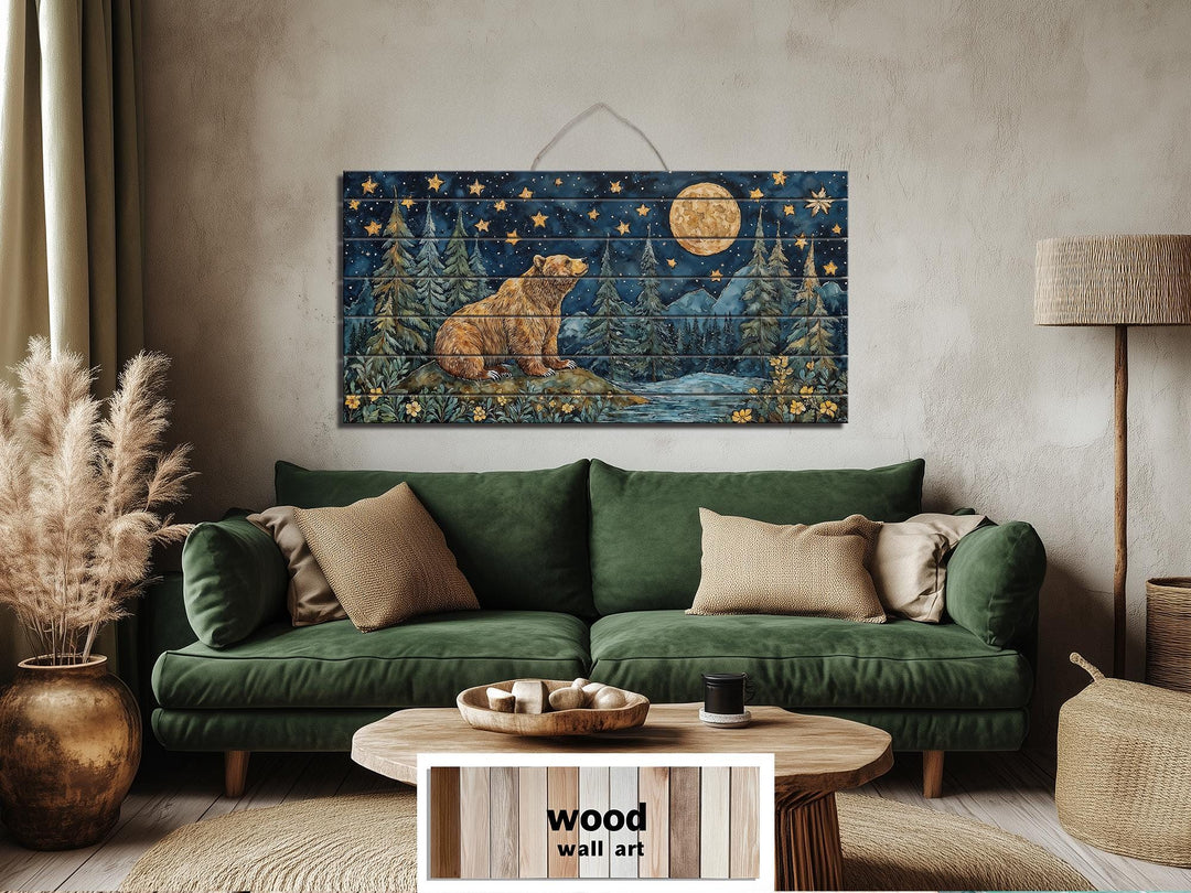 Rustic wood wall art featuring a bear under a full moon and stars above a green sofa.