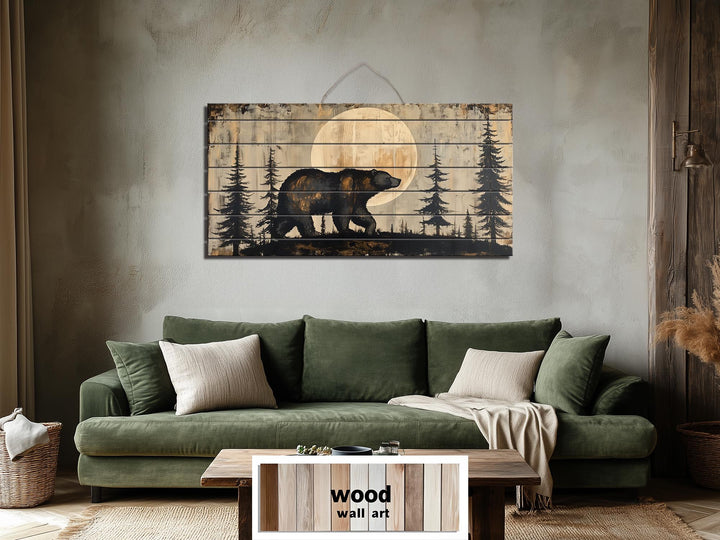 Rustic bear and moon forest scene printed on horizontal distressed wood planks above a green sofa.