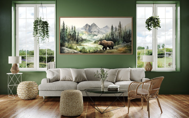Large watercolor canvas of a bear in a mountain forest hanging in a green rustic living room.