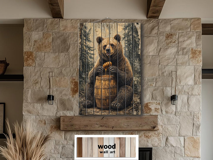 Bear with honey barrel distressed wood wall art hanging on a stone fireplace in a rustic cabin.