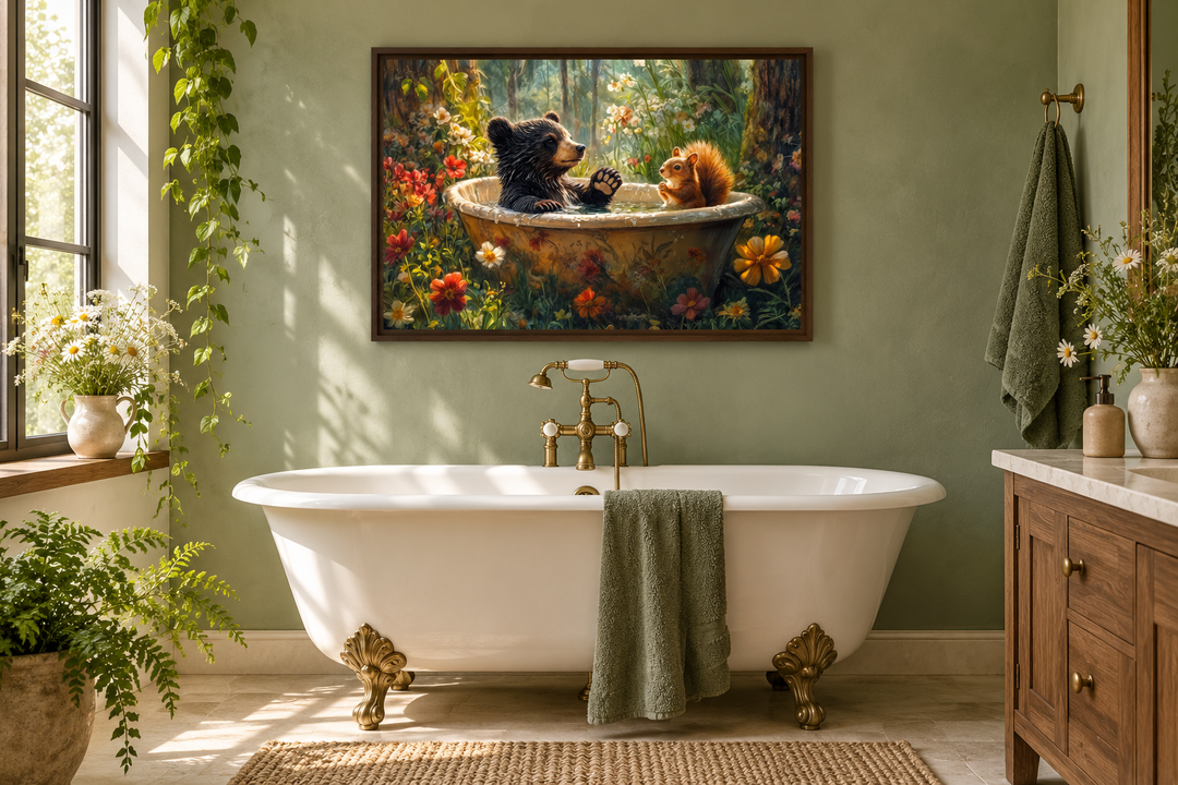 Framed canvas art of a bear and squirrel in a bathtub, hung above a white clawfoot tub in a bathroom.