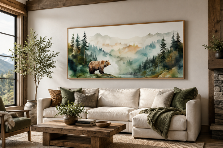Bear in the wilderness forest watercolor framed canvas wall art above a white sofa in a living room.