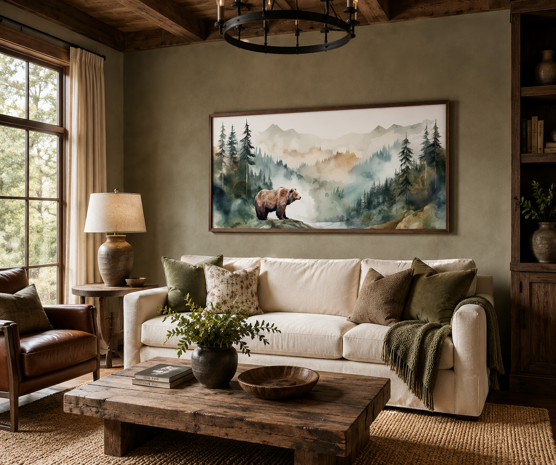 Bear in the wilderness forest watercolor framed canvas wall art above a cream sofa in a rustic room.