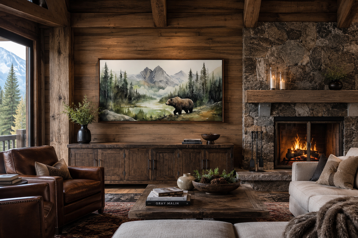 Large framed watercolor painting of a bear in a mountain forest hanging in a rustic cabin living room
