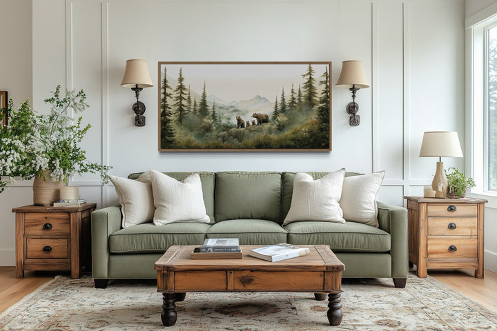 Bears family with cubs in a forest watercolor wall art framed above a green sofa in a living room.