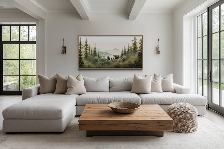 Bears family with cubs in a forest watercolor nursery wall art framed above a white sectional sofa.