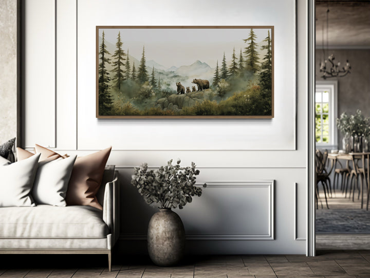 Bears family with cubs in a watercolor forest nursery wall art framed above a sofa.
