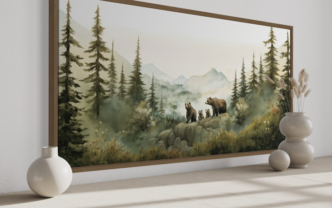 Watercolor wall art of a bear family with cubs on a rocky ledge in a misty pine forest.