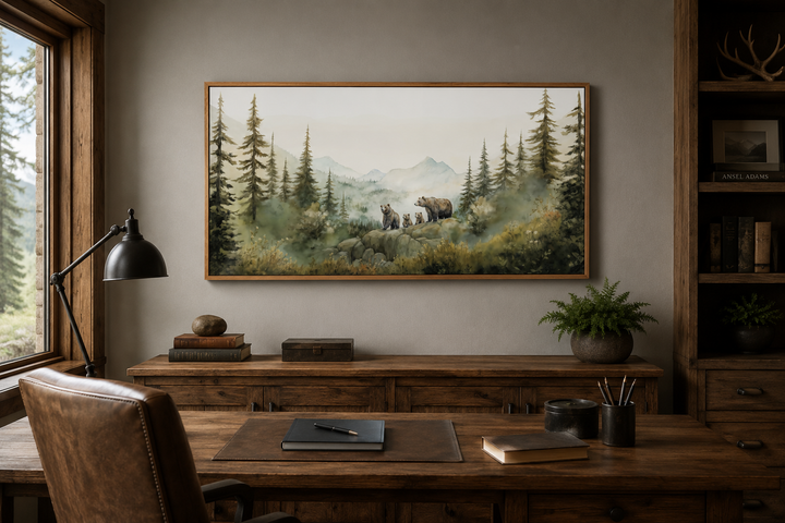 Framed watercolor wall art of a bear family with cubs in a misty forest above a wooden desk.