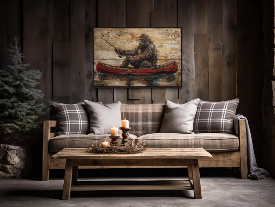 Bigfoot in a canoe rustic framed canvas wall art hanging above a sofa in a cabin-style room.