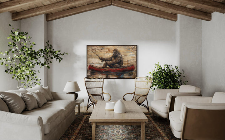 Bigfoot in a red canoe fishing, rustic framed canvas wall art in a modern cabin living room.