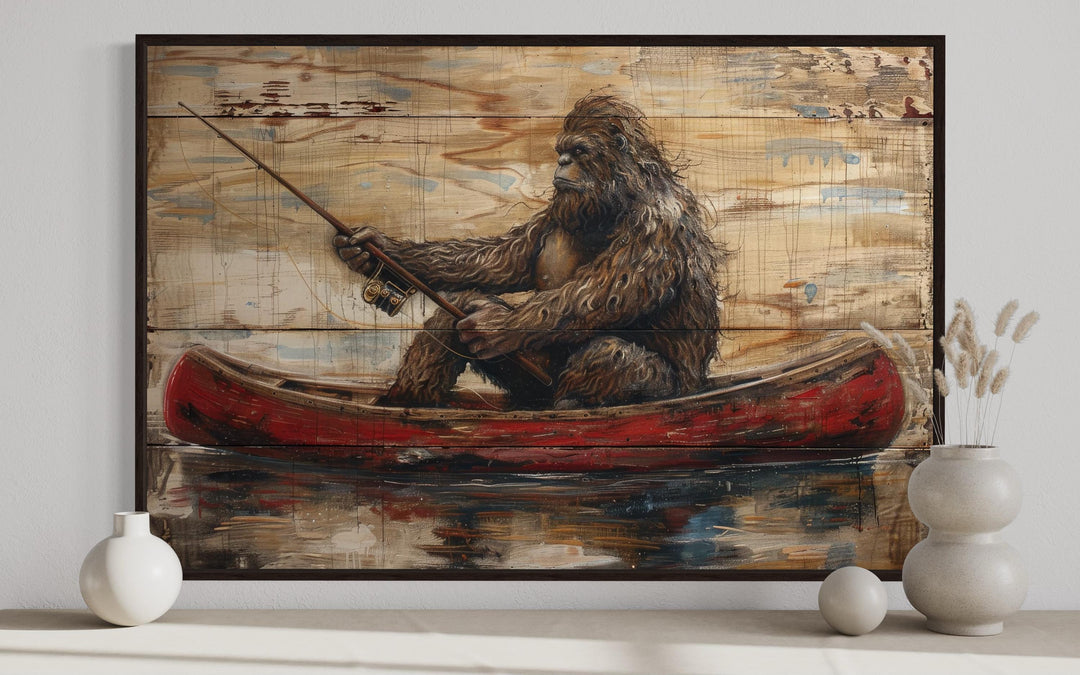 Bigfoot in a red canoe fishing with a rod, rustic framed canvas wall art on a wooden plank background.