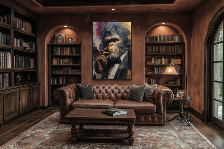 Bigfoot smoking cigar framed canvas wall art in a library with a leather sofa and bookshelves.