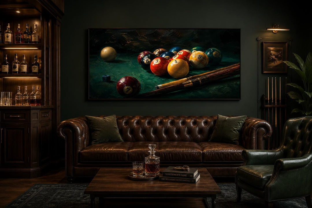 Billiard balls canvas print above a leather sofa in a dark, moody game room with a home bar.