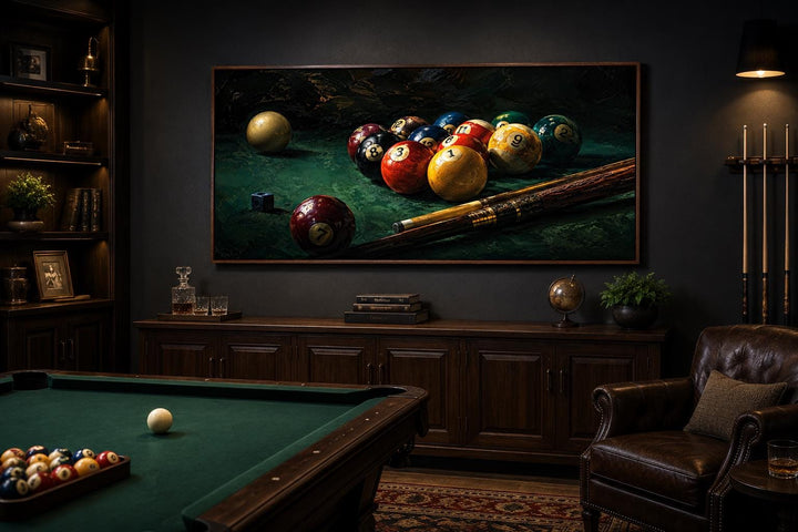 Billiard balls canvas print on a dark wall in a game room with a pool table and leather chair.