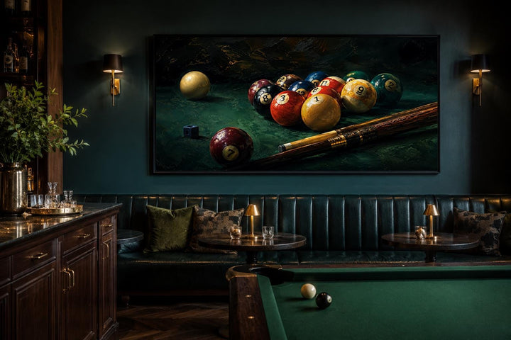 Billiard balls canvas print above a leather booth in a dark game room with a pool table.