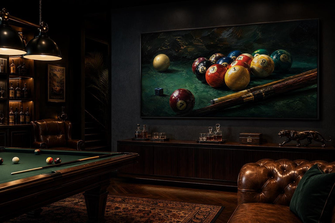 Billiard balls canvas print on a dark wall in a game room with a pool table and leather furniture.