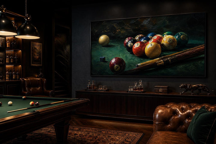 Billiard balls canvas print on a dark wall in a game room with a pool table and leather furniture.