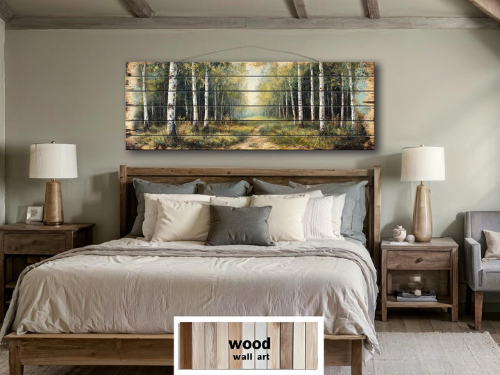A panoramic birch forest scene printed on rustic wood planks hangs above a bed in a neutral bedroom.
