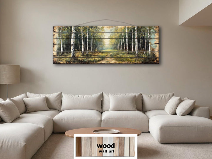 Panoramic birch forest wood wall art featuring a rustic path through trees above a modern sofa.