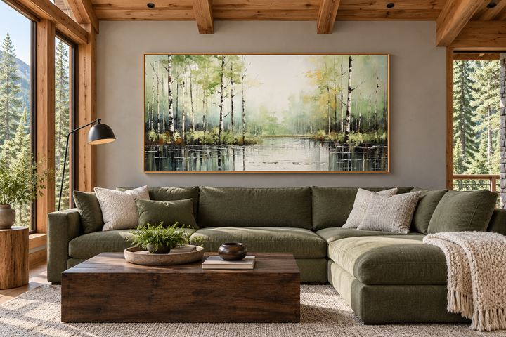 Large framed horizontal canvas painting of a birch tree forest over a living room sofa.