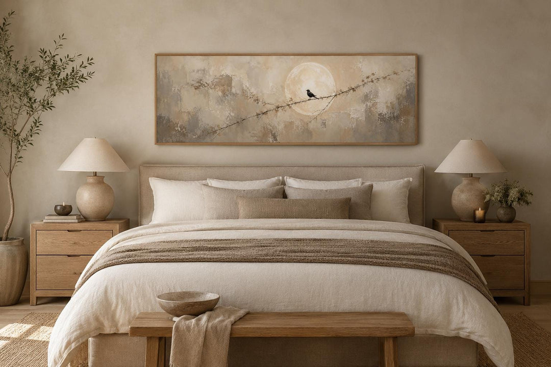Bird on branch silhouette with moon neutral beige abstract canvas print above a bed.