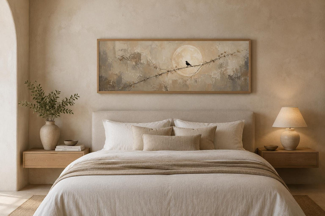 Bird on branch silhouette with moon neutral beige abstract canvas print hanging above a bed.