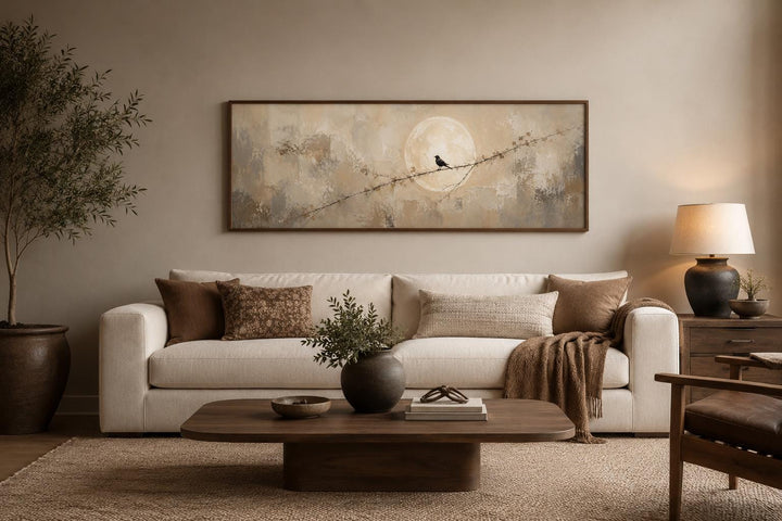 Bird on branch silhouette with moon neutral beige abstract canvas print above a sofa.