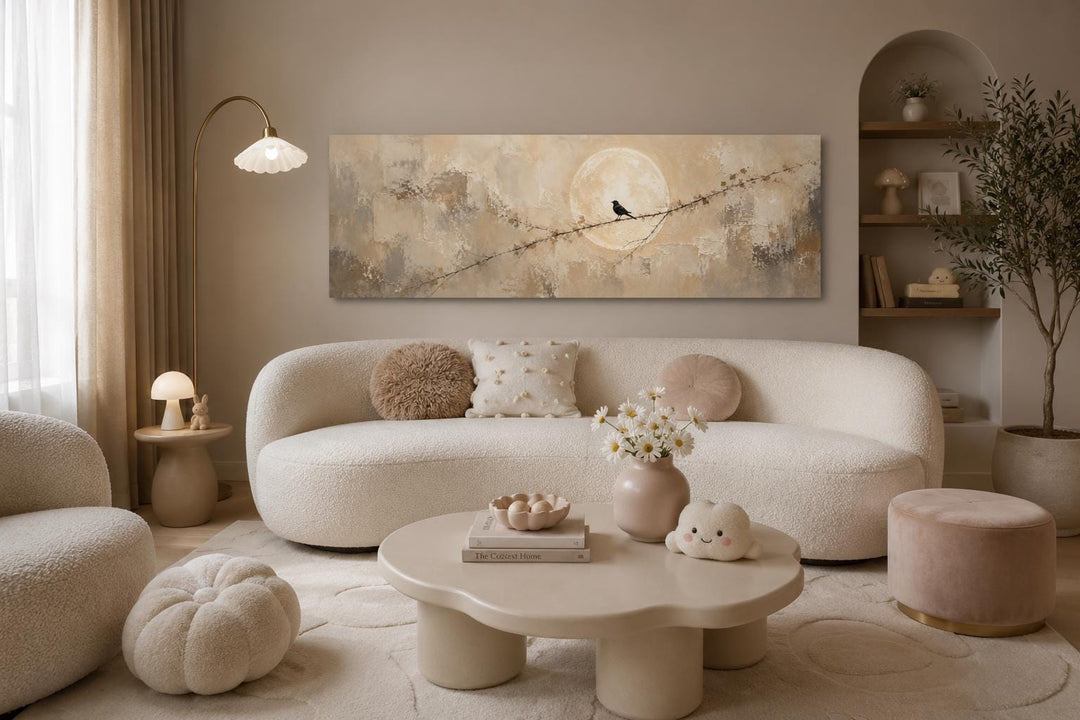 Bird on branch silhouette with moon neutral beige abstract canvas print above a white sofa.