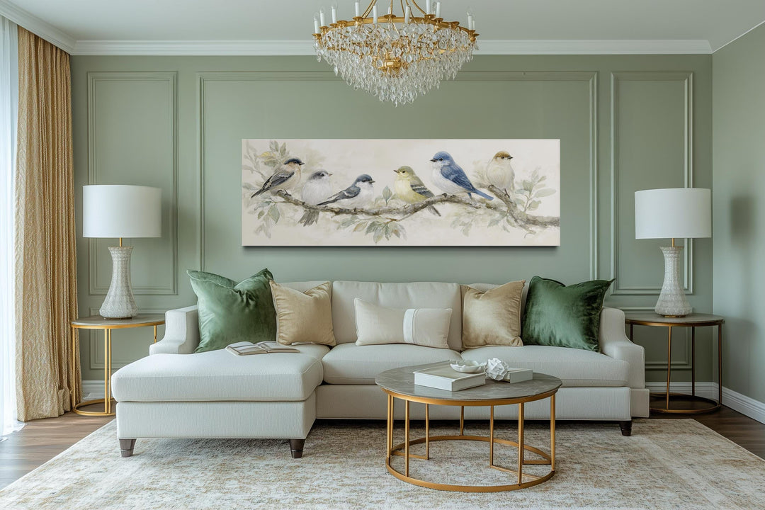 Panoramic canvas print of birds on a branch in neutral tones hanging above a modern sofa.