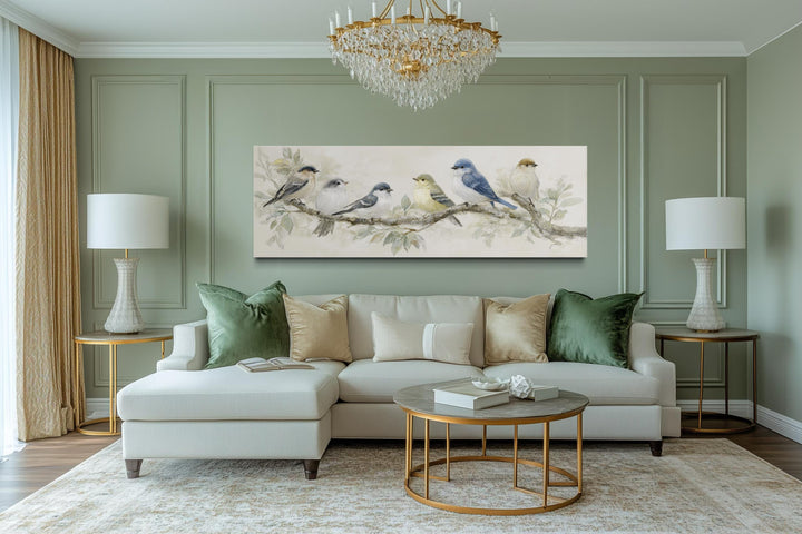Panoramic canvas print of birds on a branch in neutral tones hanging above a modern sofa.