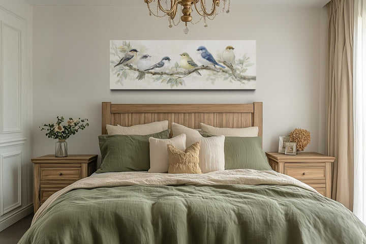 Panoramic canvas print of birds on a branch in neutral tones hanging above a wooden bed.