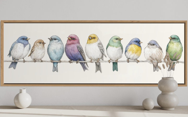 Framed horizontal canvas art featuring nine colorful songbirds perched on a wire.