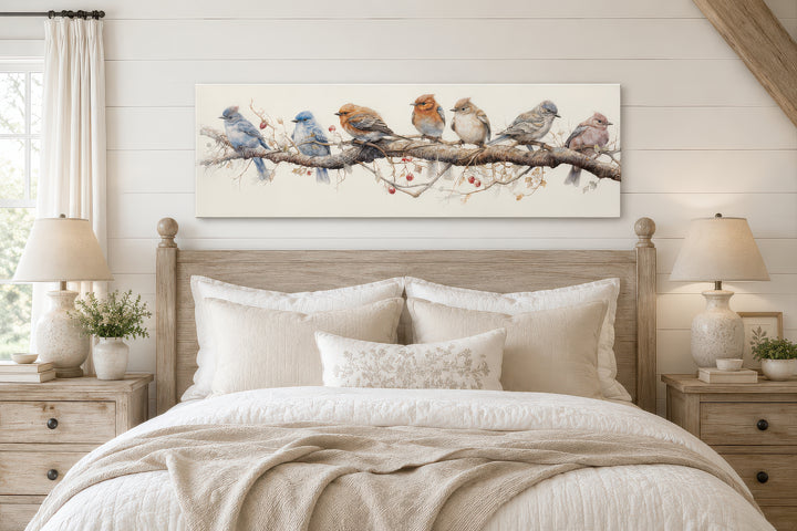 Horizontal framed canvas wall art featuring seven colorful birds perched on a branch above a bed.