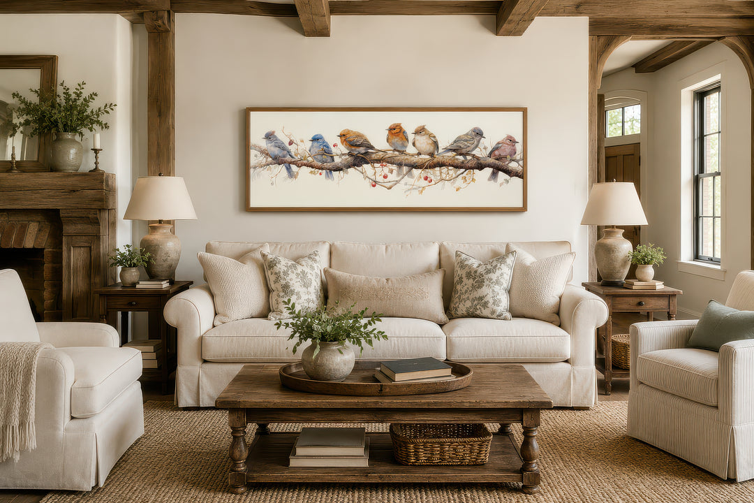 Horizontal framed canvas wall art featuring colorful birds perched on a branch above a sofa.