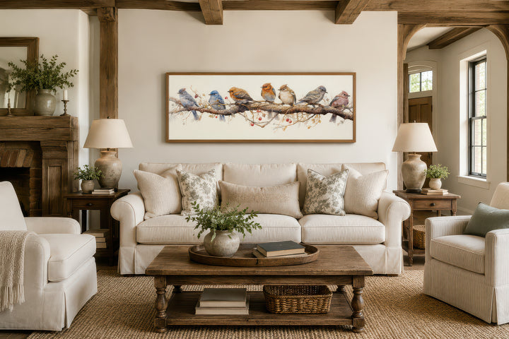 Horizontal framed canvas wall art featuring colorful birds perched on a branch above a sofa.