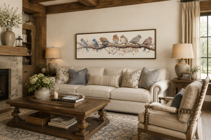 Horizontal framed canvas wall art featuring colorful birds perched on a branch above a sofa.