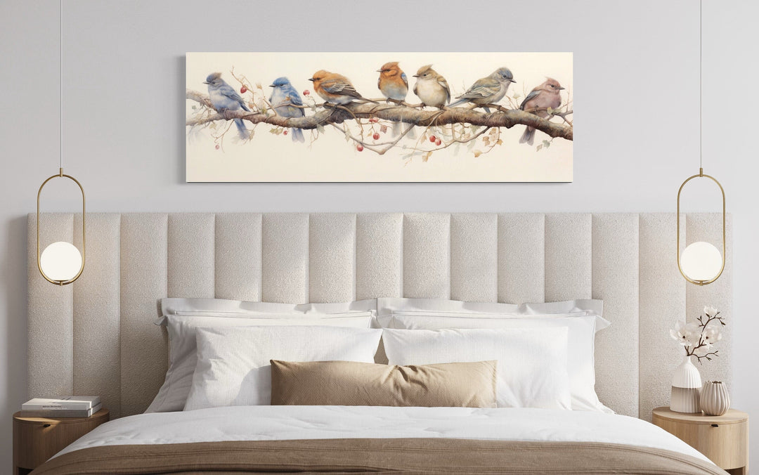 Horizontal framed canvas wall art featuring seven colorful birds perched on a branch above a bed.