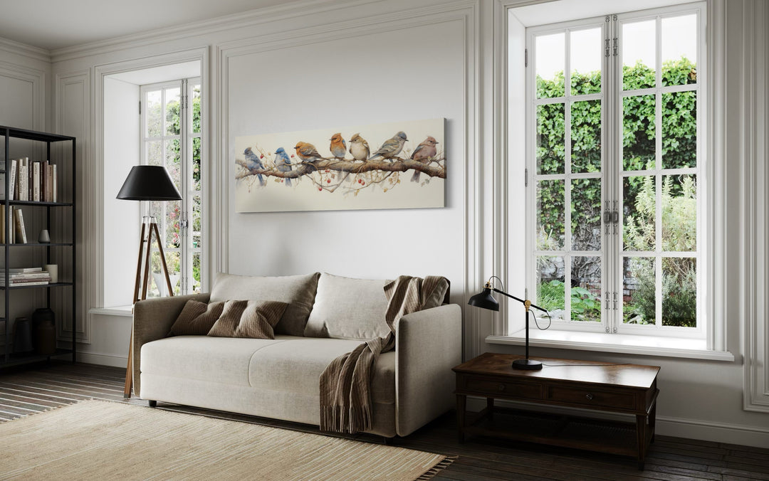 Horizontal framed canvas wall art featuring a row of colorful birds perched on a branch.