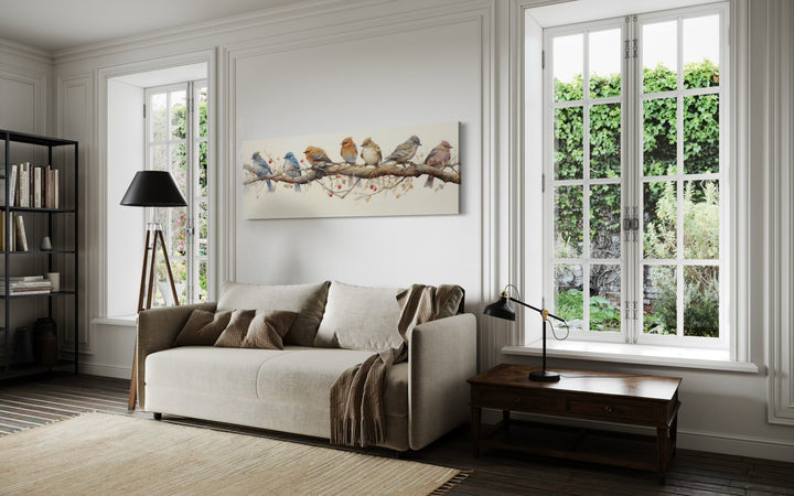 Horizontal framed canvas wall art featuring a row of colorful birds perched on a branch.