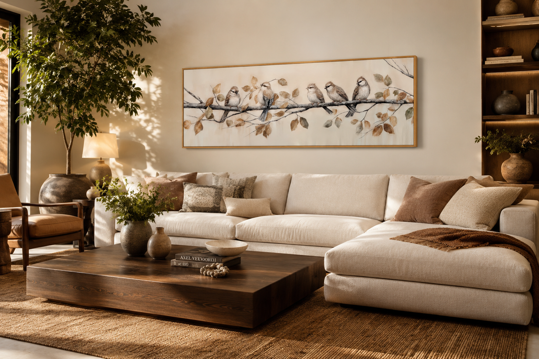 Panoramic framed canvas wall art of birds perched on a branch above a modern living room sofa.