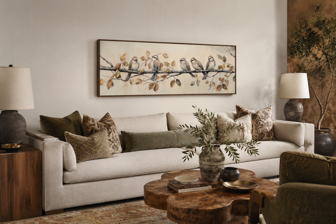 Panoramic framed canvas wall art of birds perched on a branch above a sofa in a rustic living room.