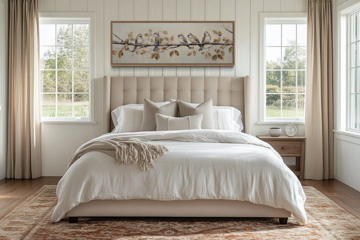Panoramic framed canvas wall art of birds on a branch above a bed in a farmhouse-style bedroom.